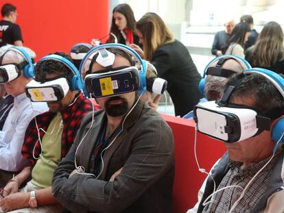 Varias personas ven un reportaje de realidad virtual en la exposición del 40 aniversario de EL PAÍS.