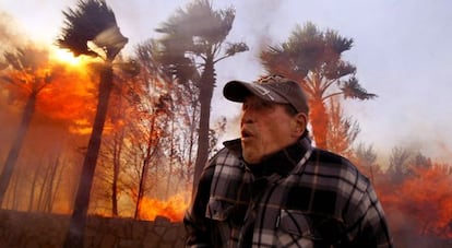 Un vecino intenta acceder a su casa incendiada en el municipio de La Nucia (Alicante) en un incendio en 2009.