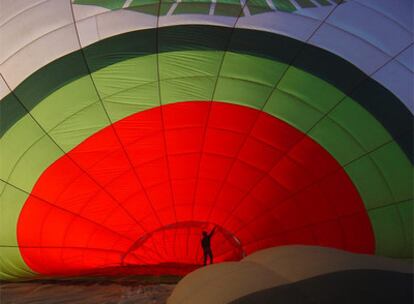 Un empleado de Green Aerostación supervisa el inflado del globo antes de un viaje.