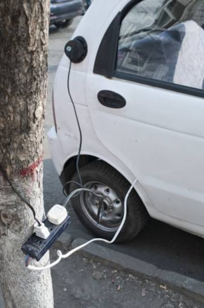 Imagen de un coche eléctrico cargándose de forma precaria en las calles de Linfen, una pequeña ciudad de la provincia norteña de Shaanxi.