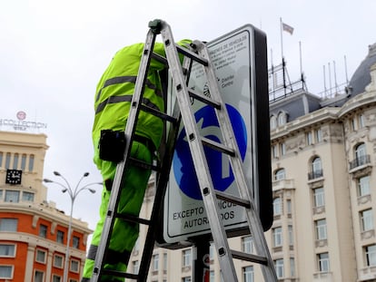 Dos operarios cambian las señales de Madrid Central en la Plaza de Cánovas del Castillo, este miércoles.