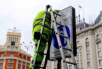 Dos operarios cambian las señales de Madrid Central en la Plaza de Cánovas del Castillo, este miércoles.