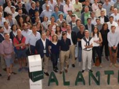 Empleados de Alantra posan junto al logo de la compañía.
