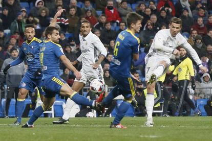 El delantero portugués del Real Madrid Cristiano Ronaldo (d) dispara a puerta frente a la defensa del Celta, durante el partido de ida de los cuartos de final de la Copa del Rey que se juega esta noche en el estadio Santiago Bernabéu.