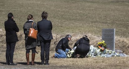 Familiares de uno de los fallecidos en el accidente de avión depositan flores en el monolito de homenaje a las víctimas, en Le Vernet (Francia).