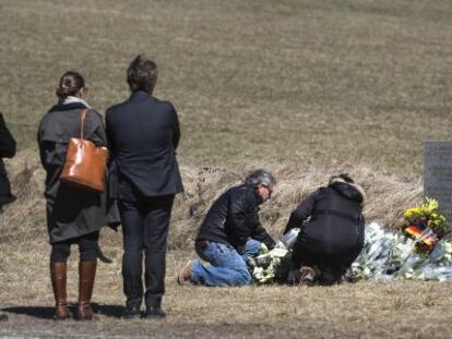 Familiars d'un dels morts en l'accident d'avió dipositen flors al monòlit d'homenatge a les víctimes, a Le Vernet (França).