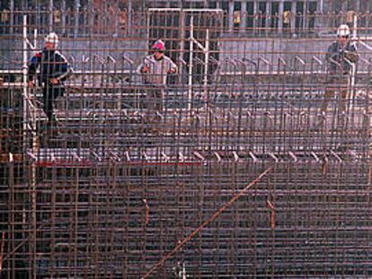 Tres trabajadores preparando un encofrado en las obras de la zona del Fòrum 2004.