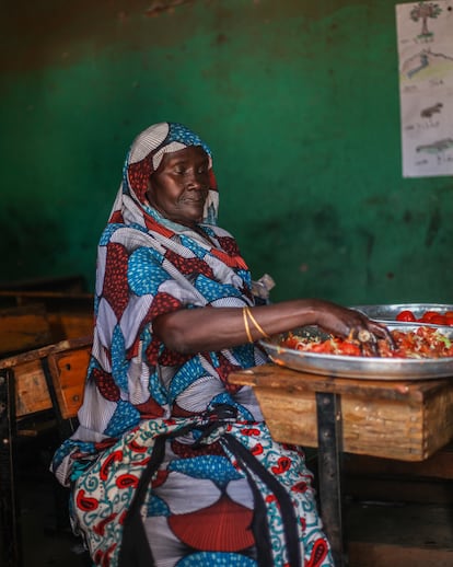 Una de las mujeres que asiste al centro día de Kibera ayuda a preparar kachumbari (una mezcla de cebollas, tomates, zanahorias, chiles y cilantro), durante una boda comunitaria celebrada en el asentamiento.