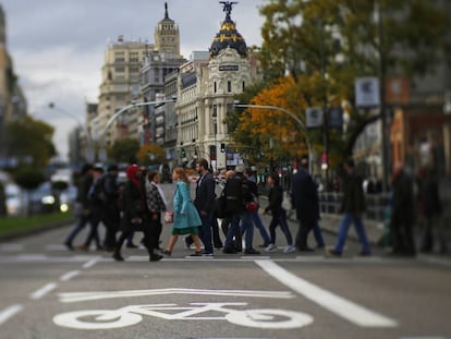 Pedestrians cross Gran Vía avenue, which is part of the Madrid Central zone.