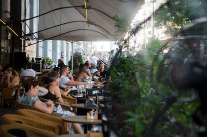 Varias personas disfrutan de ventiladores en el refugio climático instalado en el Circulo de Bellas Artes.