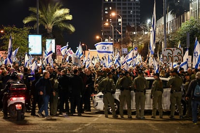 Police officers stand guard while people attend a protest against Israeli Prime Minister Benjamin Netanyahu's government, in Tel Aviv, Israel, February 24, 2024.