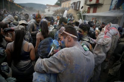 Dos personas se besan mientras celebran el lunes de ceniza participando en una colorida guerra de harina, en la ciudad portuaria de Galaxidi (Grecia), el 19 de febrero de 2018.