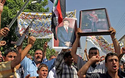 Un policía iraquí (izquierda) participa en una manifestación de seguidores de Sadam Husein en Mosul.