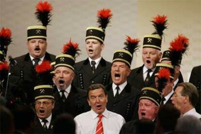 El canciller alemán Schröder canta con el coro de mineros en el congreso del SPD en Berlín.