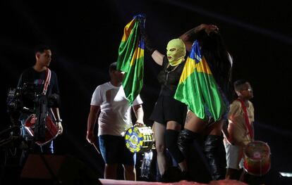 Madonna, con una capucha, sujeta dos banderas brasileñas este jueves durante el ensayo de su espectáculo para el concierto del sábado.