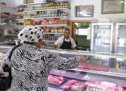 Una mujer compra carne en una tienda de productos árabes de Madrid en el primer día del Ramadán, que se prolongará durante un mes.