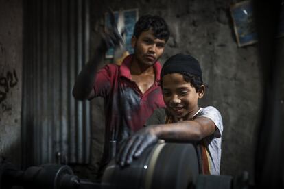Joinul, de 13 años, es empleado por su cuñado Siddik, que también fue niño trabajador y estudió gracias al apoyo de la ONG Educo. En la imagen, un compañero enseña al niño a manejar la peligrosa máquina. "No quiero estudiar", dice el pequeño.