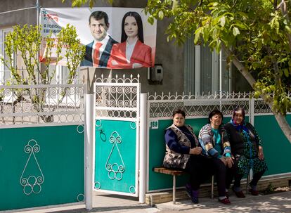 Varias mujeres, sentadas junto a un cartel electoral del partido de Shor en Svetlii, en Gagauzia, el 14 de mayo.