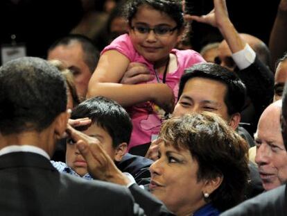 Obama (de espaldas) saluda a los asistentes a un foro de electores hispano.