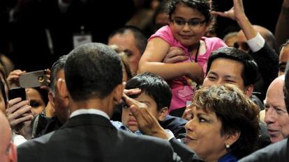 Obama (de espaldas) saluda a los asistentes a un foro de electores hispano.