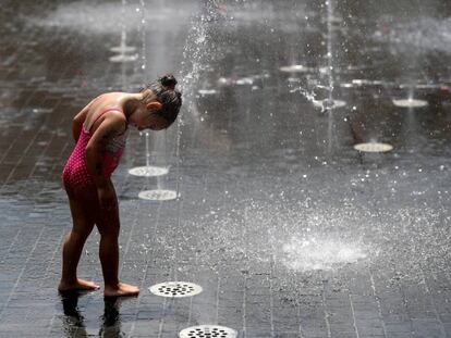 Menina se refresca em chafariz de Madri, durante uma onda de calor.