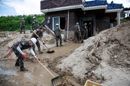 Soldados surcoreanos limpian los escombros frente a una de las viviendas afectadas por las fuertes lluvias en Yecheon-gun, el lunes 17 de julio.
