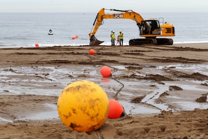 Unos operarios participan en las obras de tendido de un cable submarino de Google en Sopela (Bizkaia).