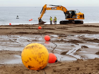 Unos operarios participan en las obras de tendido de un cable submarino de Google en Sopela (Bizkaia).