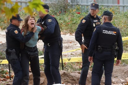 Una manifestante es retenida por agentes de Policía durante la protesta este lunes contra la tala de árboles en el parque de Arganzuela, prevista en las obras de ampliación de la línea 11 de Metro de Madrid entre Plaza Elíptica y Conde de Casal.