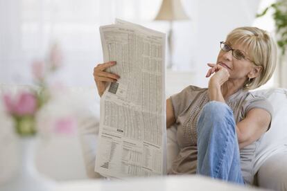 Una mujer leyendo el periódico.