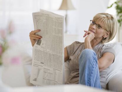 Una mujer leyendo el peri&oacute;dico.