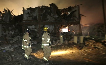 Dos bomberos inspeccionando la zona de las explosiones.