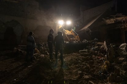 A backhoe works on the remains of the three-story house where Amina and her son are buried. The three-story building collapsed, killing Amina and her four children.