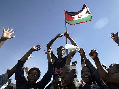 Unos subsaharianos enarbolan la bandera del Frente Polisario en el campamento de Bir Lehlu donde han sido acogidos.