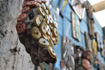 In this April 4, 2016 photo a wooden snake with inlaid bottle caps hangs in an open-air museum and art workshop off a trash-strewn street cutting through some of the poorest neighborhoods in Port-au-Prince, Hiati. The snake was created in Haitian the Atis Rezistans workshop, who's work has been exhibited in cities such as Paris, London, and Los Angeles. There are sculptures included in the permanent collections of museums, including the Frost Art Museum in Miami. (AP Photo/David McFadden)