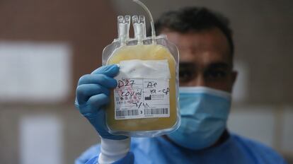 Un trabajador sanitario sostiene una bolsa de plasma sanguíneo de un infectado de covid en una foto de archivo.