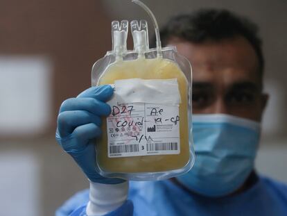 Un trabajador sanitario sostiene una bolsa de plasma sanguíneo de un infectado de covid en una foto de archivo.