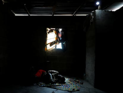 Una mujer llamada Recent Kodjo descansa en su habitación iluminada con una bombilla alimentada por la energía solar en la comunidad de Sagbo-Kodji, en Lagos, Nigeria 25 de abril de 2020.