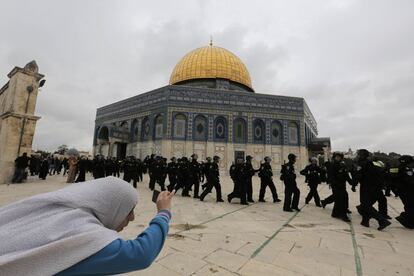 Una mujer palestina hace una foto a la policía israelí delante de la Cúpula de la Roca durante los enfrentamientos con manifestantes que lanzaban piedras después de la oración del viernes, fuera de la mezquita al-Aqsa en el compuesto conocido por los musulmanes como Noble Santuario y para judíos como el Monte del Templo.