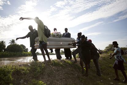 Varias personas cargan el ataúd de un familiar que murió de cólera en Robine, al norte de Haití.