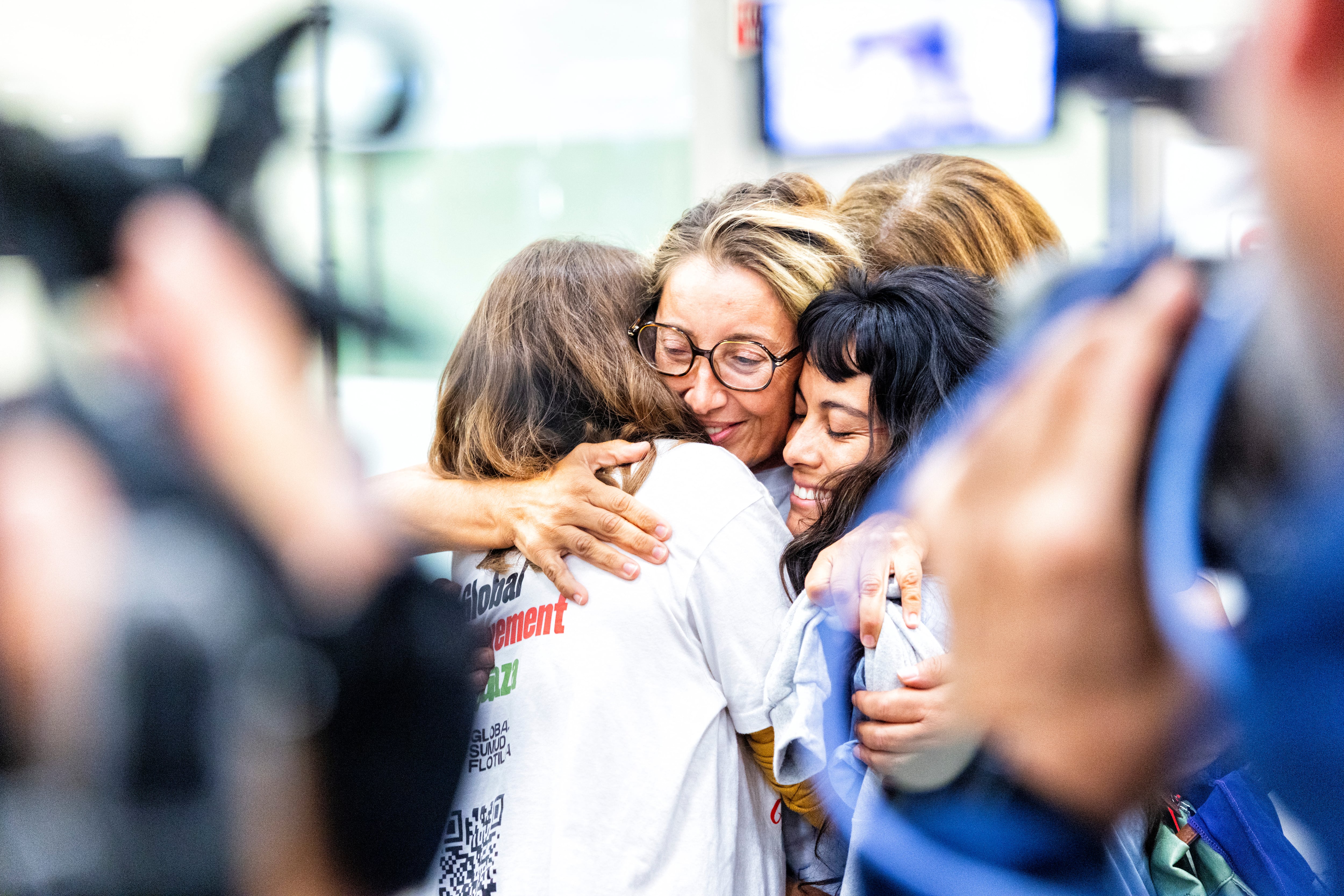 Reyes Rigo (centro) abraza a Nicole León (derecha) y otra compañera a su llegada a Madrid, este lunes.