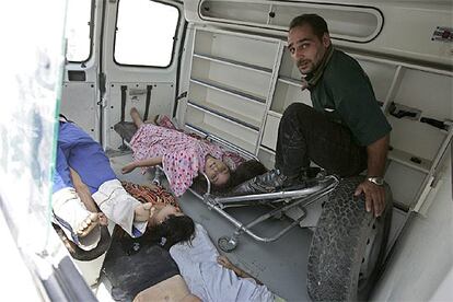 Un miembro del personal sanitario de una ambulancia, junto a los cadáveres de unos niños que han perecido víctimas de la turbamulta en un puente sobre el Tigris en Bagdad.