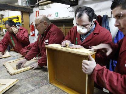 Cuatro hombres aprenden carpintería en el taller del centro de rehabilitación Lenda, que promueven las familias de Redondela.