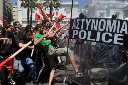 Manifestantes armados con palos y policías chocan en los enfrentamientos registrados ayer en Atenas, durante el Primero de Mayo, ante la sede del Parlamento griego.