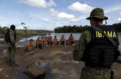 Garimpeiros detidos por agentes do Ibama no rio Uraricoera durante uma operação contra a mineração ilegal de ouro em terras indígenas, no coração da floresta amazônica.