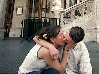 Una pareja se besa en la Grand Place de Bruselas.