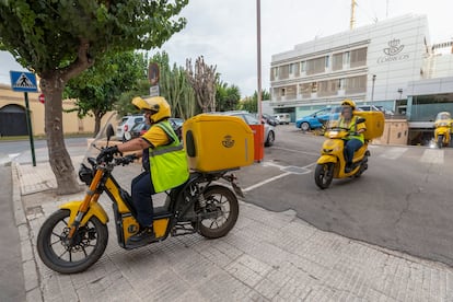 Trabajadores de Correos salen de la sede central, en la plaza Circular de Murcia, para recoger los resultados del escrutinio en los colegios electorales de la ciudad. 