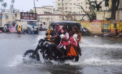 Residentes circulan con una motocicleta por una calle inundada en Puri, Odisha. 