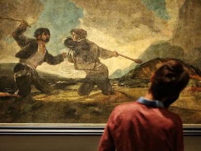 Un visitante contempla la obra 'Duelo a garrotazos', de Goya, en la sala de las pinturas negras del Museo del Prado.