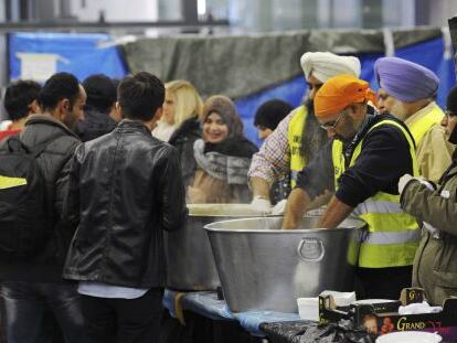 Voluntarios alimentan a refugiados sirios en la estación de tren de Viena, la semana pasada.